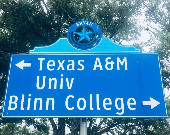 Road Sign in Bryan, Texas that points to the direction of Texas A&amp;M University and Blinn College